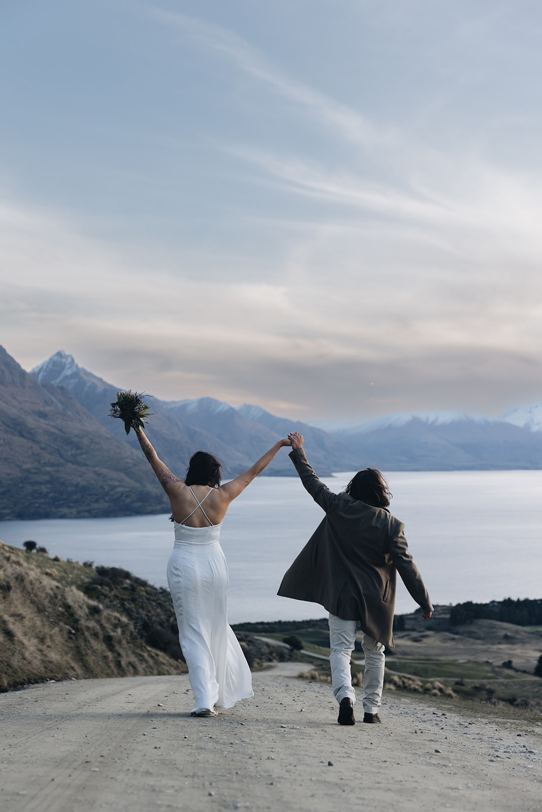 Sea to Sky elopement — couple celebrating on a mountain road above a lake in British Columbia